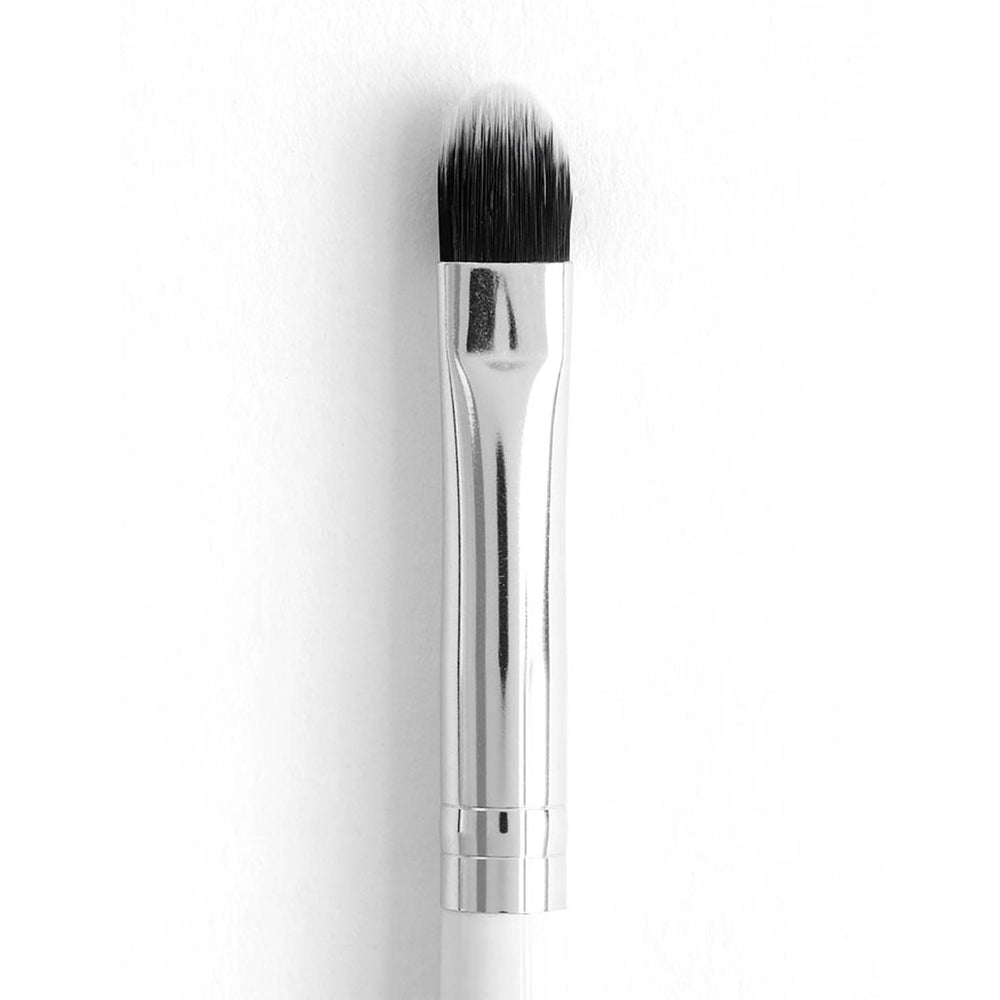 ColourPop Small Shader makeup brush packing and blending eyeshadow with dense rounded synthetic bristles, a polished silver ferrule, and a white handle, shown close-up against a clean white background.