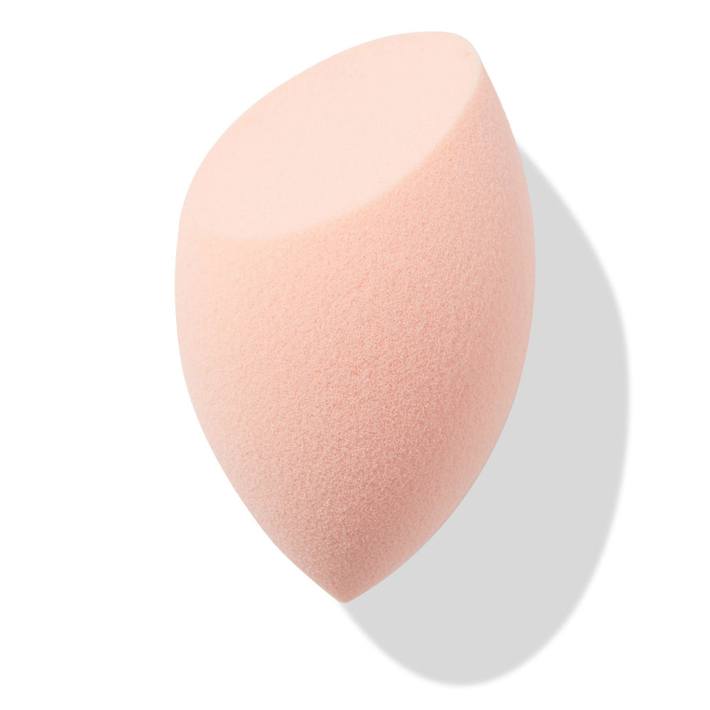 Peach teardrop Blending Sponge with a flat slanted edge resting at an angle, showing fine foam texture for seamless foundation and concealer blending, isolated on white with soft shadow; a must-have in ColourPop Makeup Tools & Accessories.
