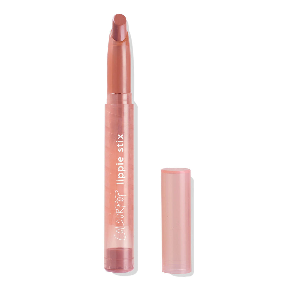 ColourPop Lippie Stix in Slacker stands uncapped, angled rosy nude bullet exposed, in a slim translucent pink tube with lippie stix branding, cap placed beside it on a white background.