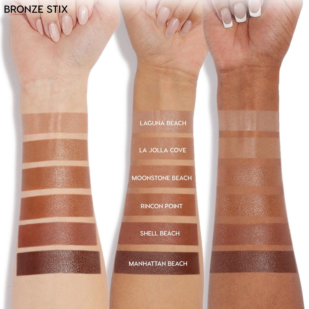 ColourPop Bronzer Stix swatches on three arms show the La Jolla Cove shade - a warm medium bronze - applied in labeled stripes between Laguna Beach and Moonstone Beach, demonstrating payoff across fair, medium, and deep skin tones.