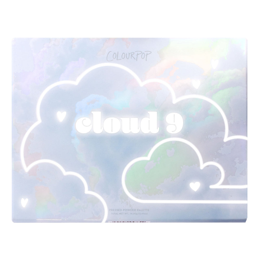 Cloud 9 ColourPop Shadow Palette sits closed, showing a holographic pastel sky design with white outlined clouds, tiny heart icons, and bold 'cloud 9' lettering on the lid, a rectangular pressed powder eyeshadow palette on a white backdrop.