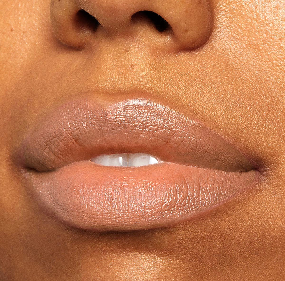 Lips wearing ColourPop Lippie Stix in Cookie, a warm nude‑beige shade, softly pressed together to display smooth, even coverage and a natural sheen in a tight close-up beauty shot.