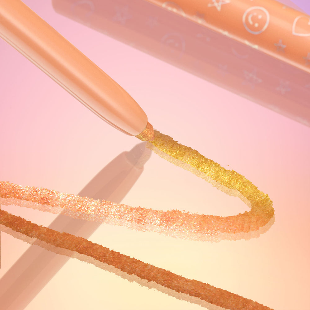 Movie Star ColourPop Chrome Crème Gel Liner drawing a smooth, glittering gold-to-peach chrome line on a glossy surface; peach twist-up pencil with star and smiley icons, set against a pink-to-gold gradient background.