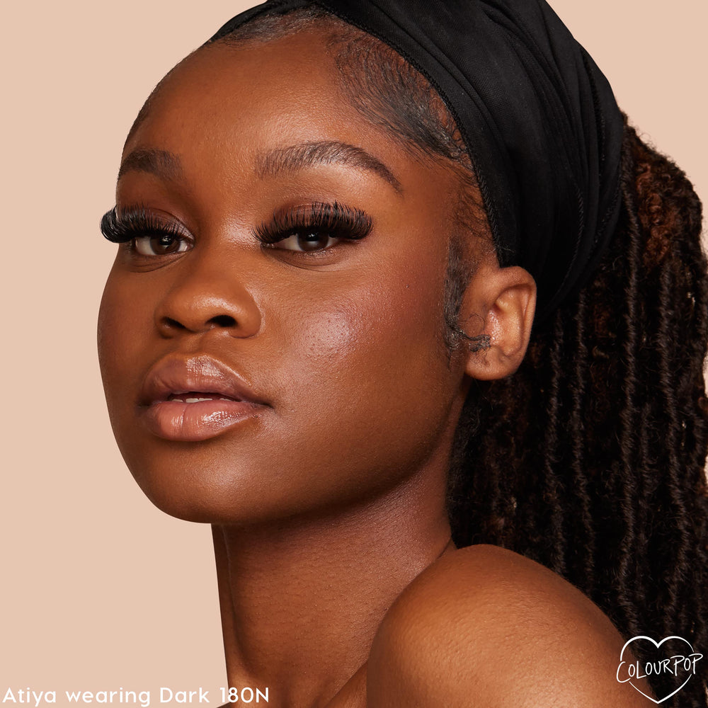 ColourPop Pretty Fresh Creamy Concealer in Dark 180 N evens the model’s complexion with natural, medium coverage and a soft glow; close-up headshot against a beige backdrop highlights the neutral undertone and seamless finish.