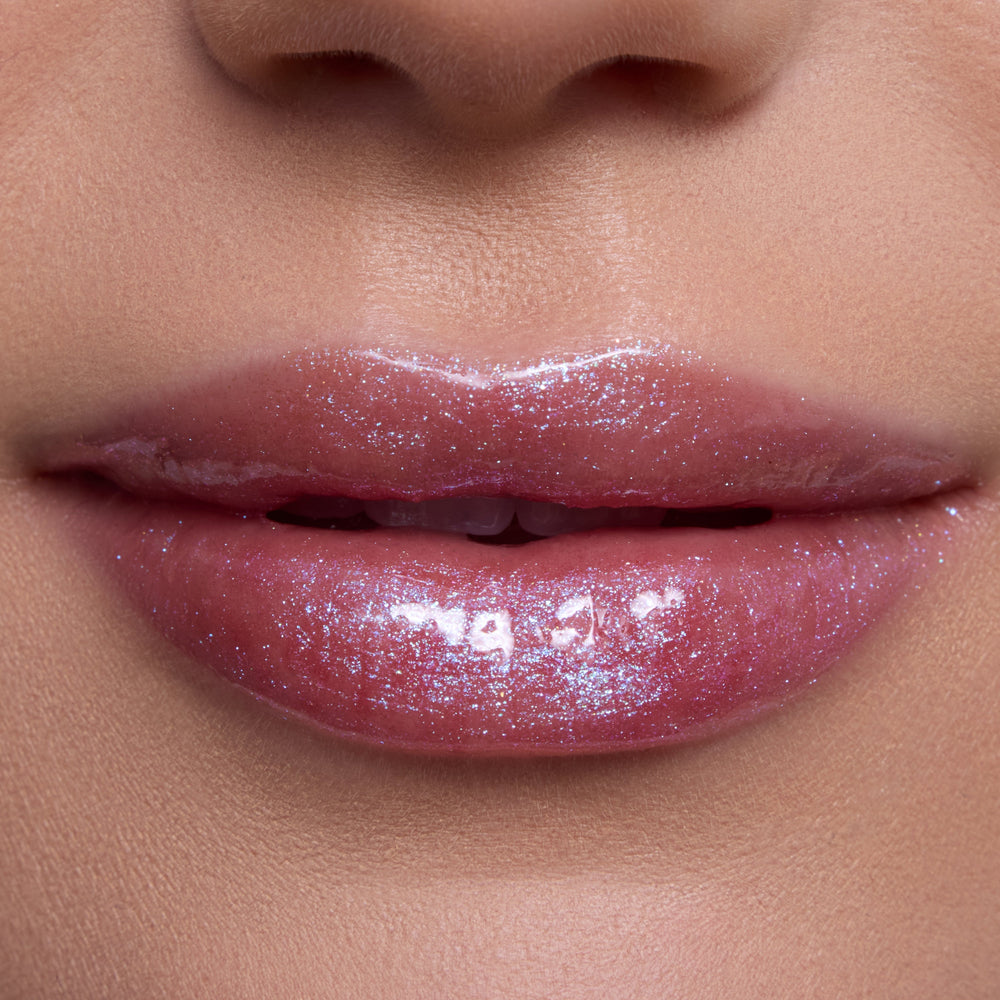 Close-up of lips wearing Courageous Rapunzel Ultra Glossy Lip, a shimmering pink Disney Princess lip gloss with high-shine, iridescent sparkle on smooth, hydrated lips against natural skin tone background.
