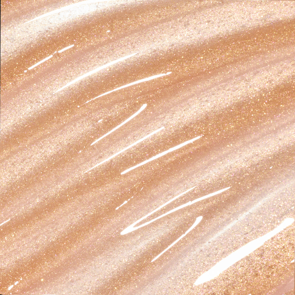 Colourpop Fresh Kiss Glossy Balm Buttery Pancakes swatch showing sheer nude lip gloss & lip oil texture with gold, pink, and silver sparkle streaked across a shimmery beige background, highlighting its high-shine finish.