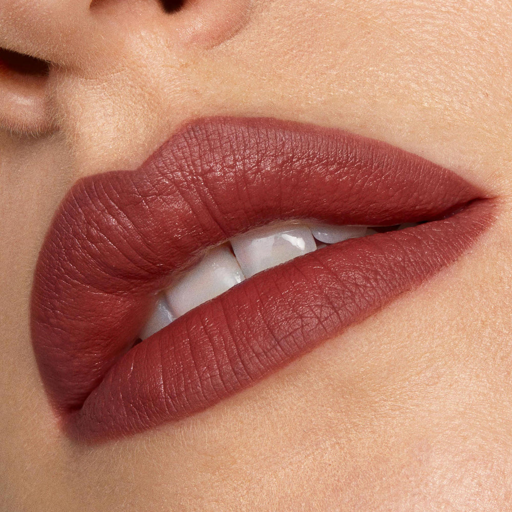 Full lips lined and filled with Grunge ColourPop Lippie Pencil, showcasing a soft-matte warm brown‑rose hue in a tight close-up with teeth slightly visible, emphasizing crisp edges and smooth, even coverage.