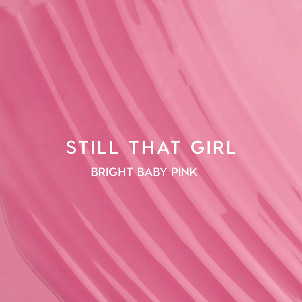 Still That Girl Ultra Glossy Lip Heart to Get swatch showing smooth, bright baby pink lip gloss spread in soft ridges across a solid pink background, highlighting its high-shine, creamy texture for bold, glossy lips.