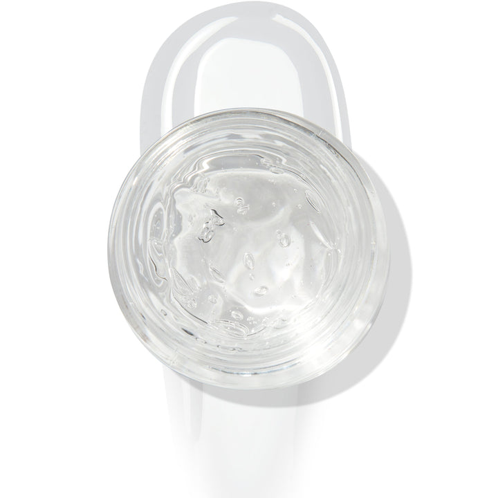 In The Clear Face & Eye Gloss in an open round jar gleams with a glossy swipe beneath it on a white background, showcasing the ColourPop Face & Eye Gloss for dewy, glass-skin shine on lids and cheeks.
