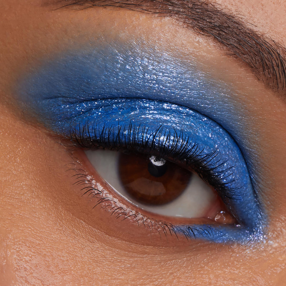 Brown eye wears Stargaze, a ColourPop Jelly Much Shadow, swept across the lid in glossy cobalt blue with subtle silver shimmer, extending to the inner lower lash line for a bold, saturated finish.
