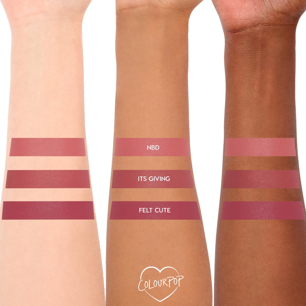 ColourPop Lippie Stix NBD swatched on three arms, displaying a soft rose-pink satin lip color across light, medium, and deep skin tones; stacked swatches also include Its Giving and Felt Cute for comparison.