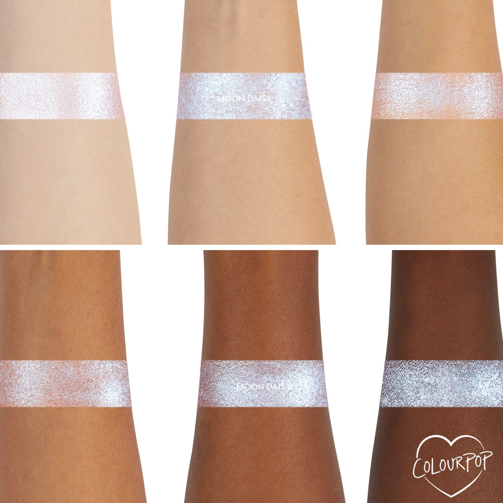 ColourPop Moon Daisy Super Shock Shadow swatches showing a high-shine icy lavender-blue shift across six arms from light to deep skin tones, demonstrating smooth metallic payoff and sparkle; ColourPop heart logo in the bottom right.