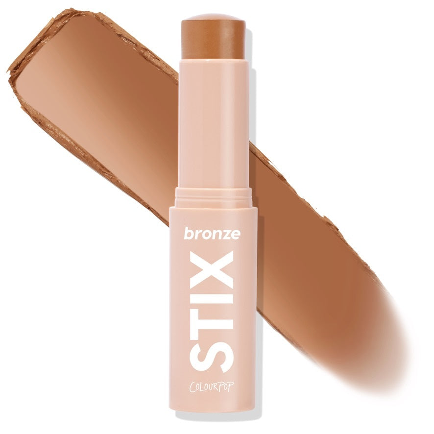 ColourPop Bronzer Stix in Moonstone Beach standing uncapped, the twist-up cream bronzer bullet leaving a warm tan swipe behind it, shown close-up on a white background for shade reference; ideal for sun-kissed contour.