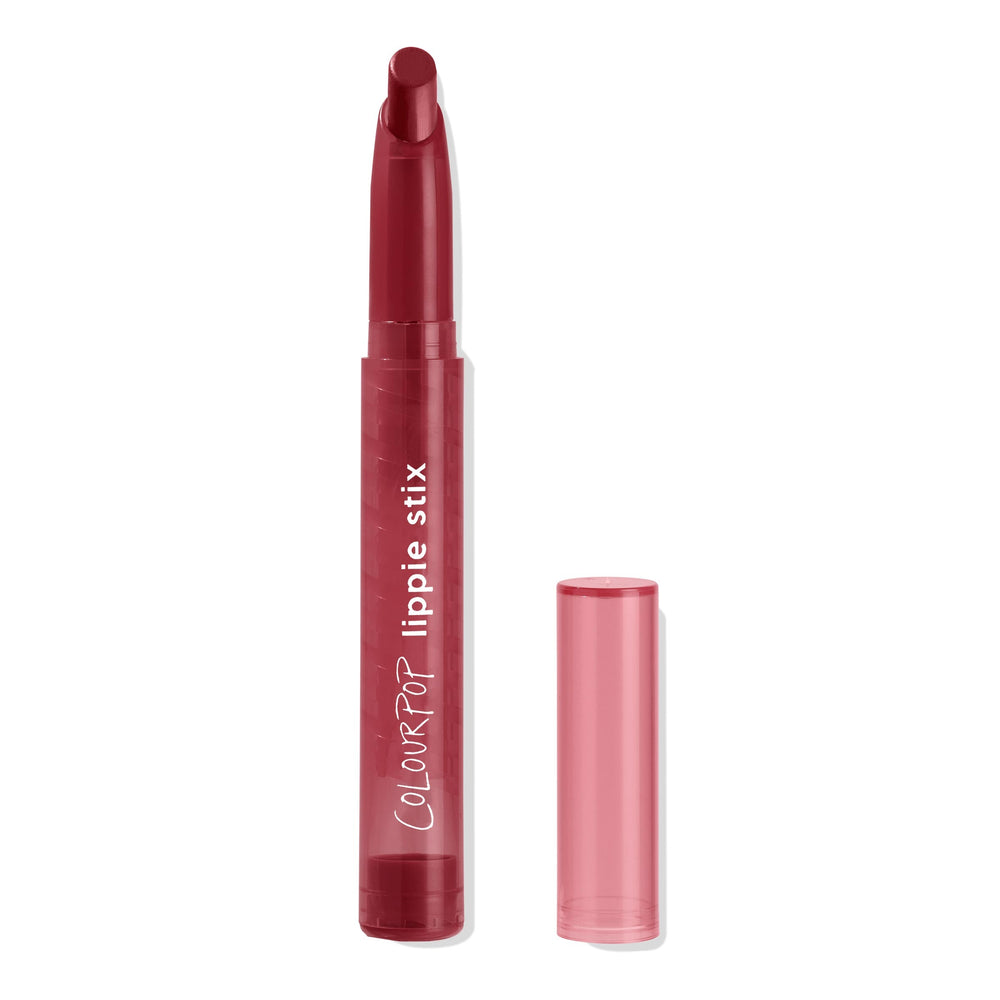 ColourPop Lippie Stix in My Bad stands uncapped, angled berry-red bullet exposed, maroon tube showing lippie stix branding with a translucent rose cap beside it, set against a clean white background.