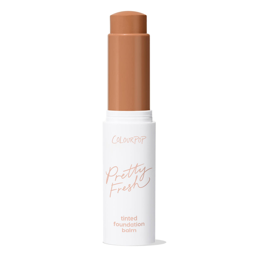 ColourPop Pretty Fresh Tinted Foundation Balm in Dark 18 - twist-up stick stands open with the warm deep shade bullet extended, housed in a white tube with peach lettering against a clean white background.