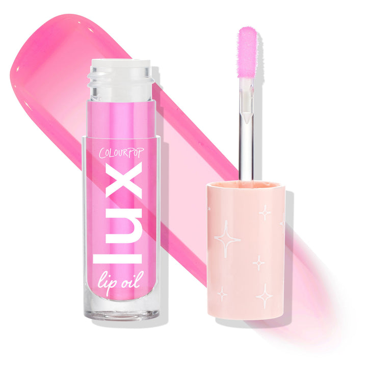 Raspberry Mojito ColourPop Lux Lip Oil shown open - clear tube with white Lux logo and a doe‑foot applicator coated in glossy hot‑pink tint - beside a peach cap with white starbursts and a bold pink swatch on a white background.