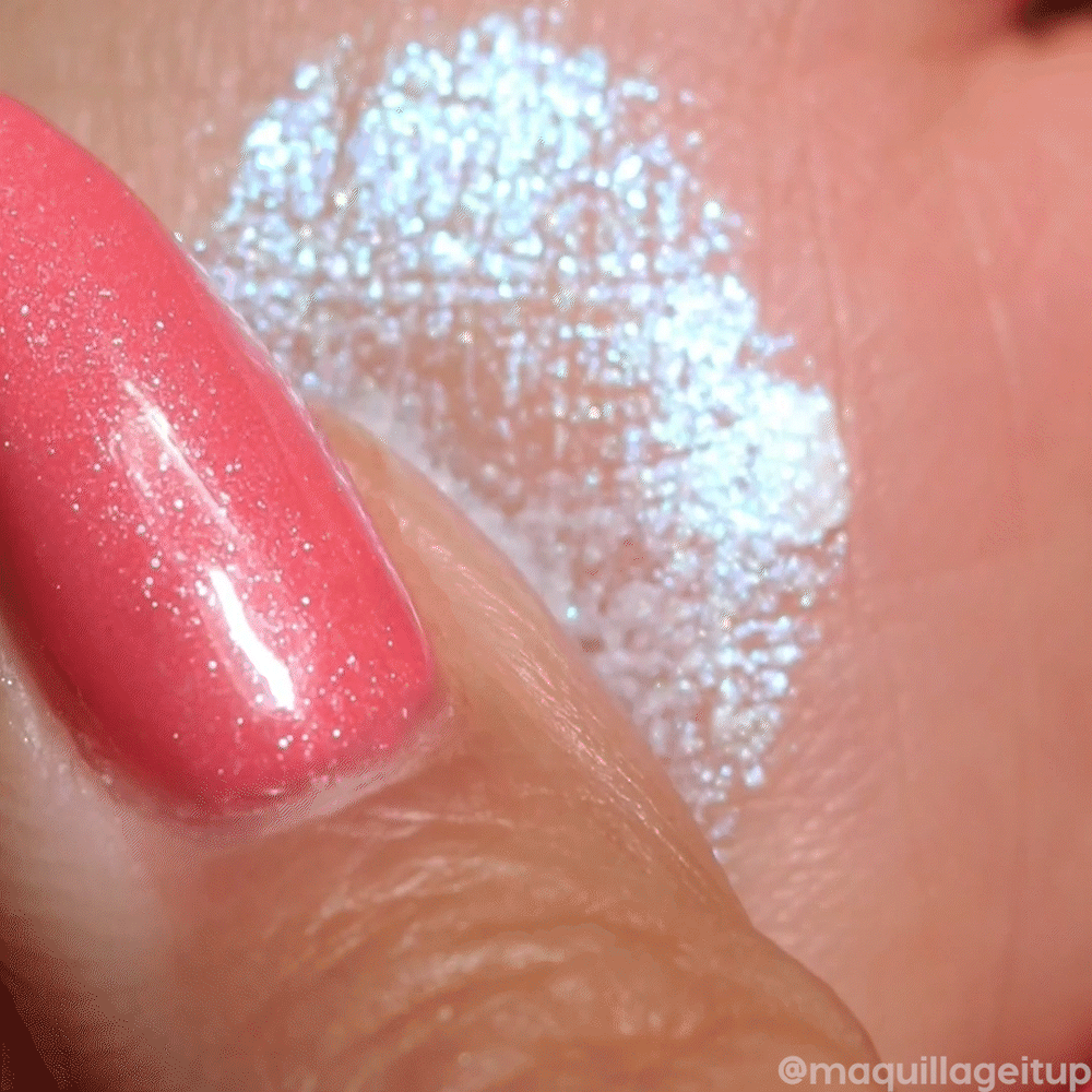 ColourPop Jelly Much Shadow Super Cool swatch shimmering icy white-blue on skin, the gel-cream eyeshadow catching light for a wet metallic finish as a fingertip with pink glitter polish blends the shade.