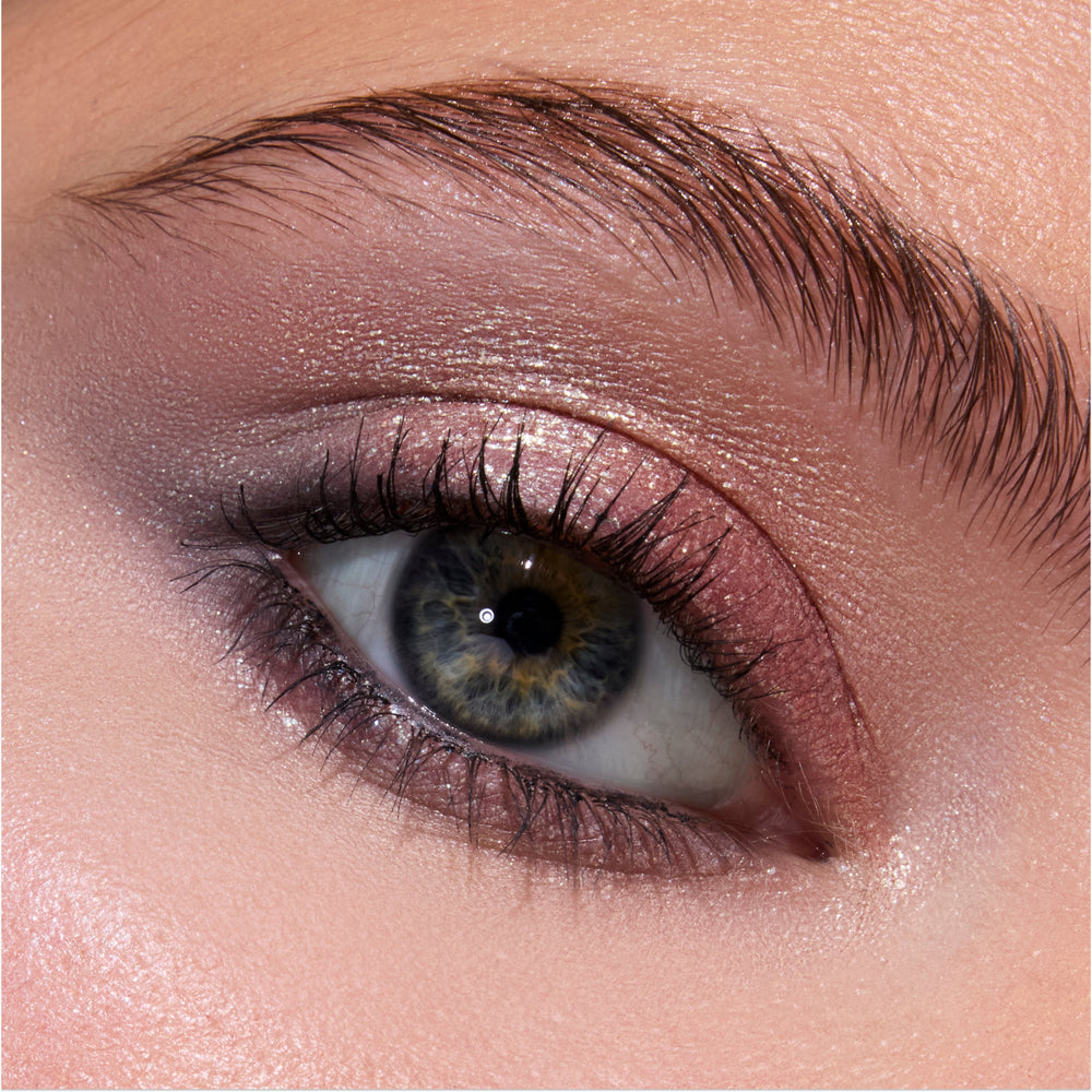 Close-up of a blue-green eye wearing Twilight-inspired Coven Clash Jelly Much Duo, showing shimmery mauve and rose-gold eyeshadow blended across the lid and crease for a soft, metallic glam look.