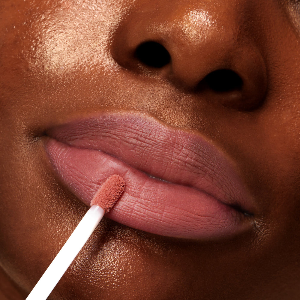 Doe-foot applicator swipes a dusty-rose tint onto softly matte lips, showcasing Mood 24/7 from the ColourPop Cheek & Lip Set in a tight beauty close-up that highlights smooth texture and precise application.